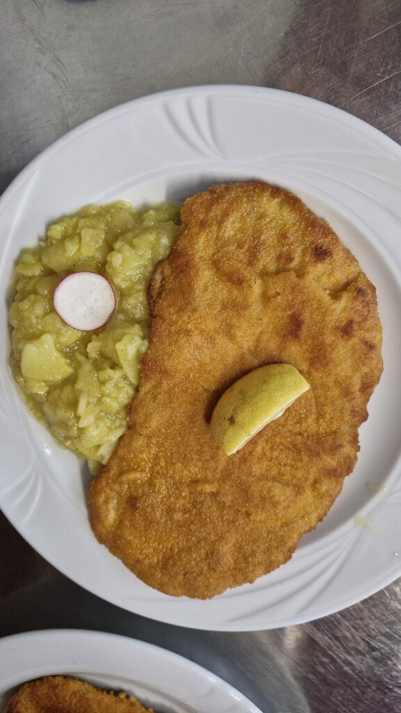 Schweineschnitzel mit hausgemachtem Kartoffelsalat und Zitronenspalte, ein beliebtes Tagesessen