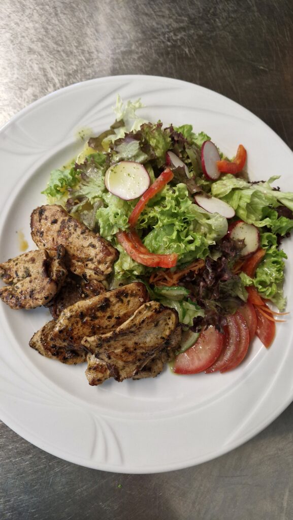 Gemischter Salatteller mit gebratenen Schweinefiletstreifen, Kartoffelsalat, grünem Salat, Tomaten, Karottensalat, Gurken, Paprika, Radieschen