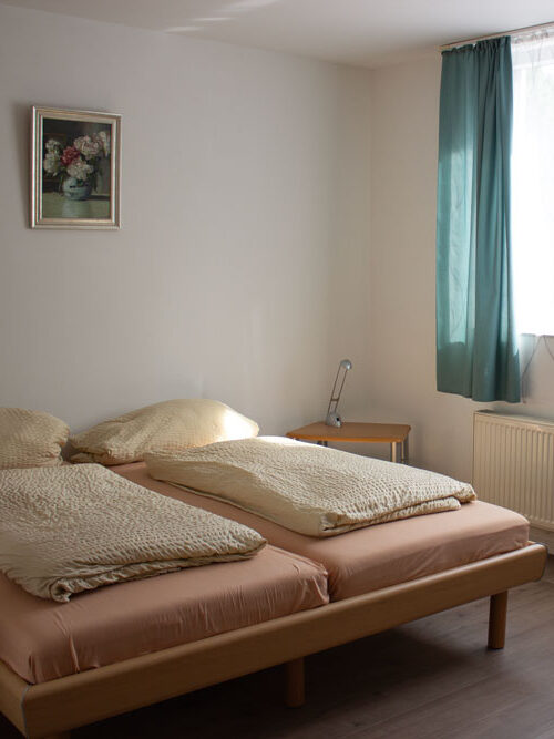 Doppelbett mit Nachttischen an großem Fenster
